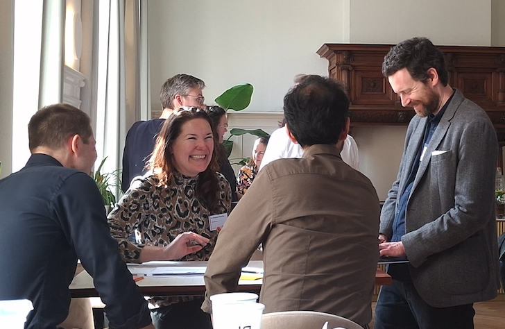 people sitting around a table, laughing