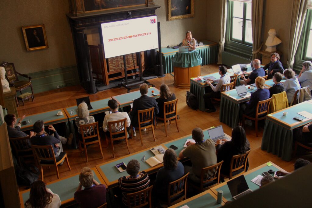 People in sitting in a lecture hall watching two speakers holding a presentation